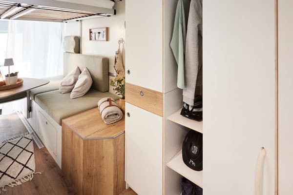 Wohnwagen mit Dachzelt Knd im sitzt im Dachzelt und genießt die Aussicht